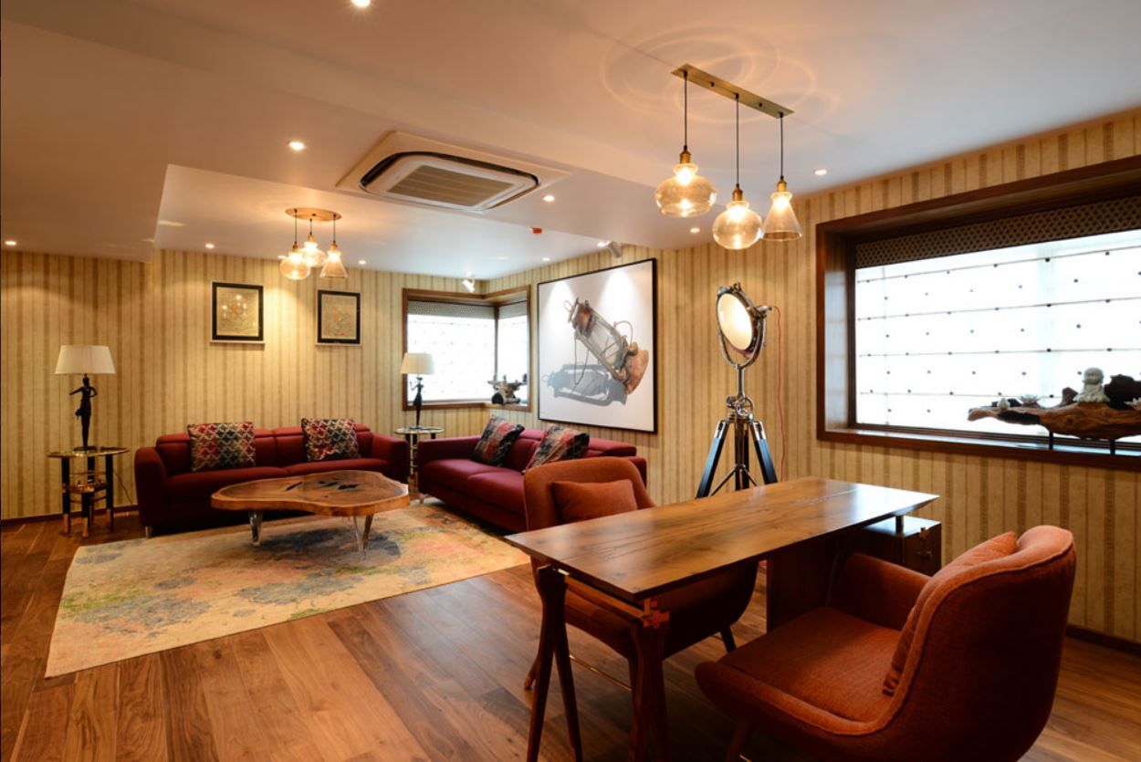 Informal sitting area with red sofas and tripod studio lamp